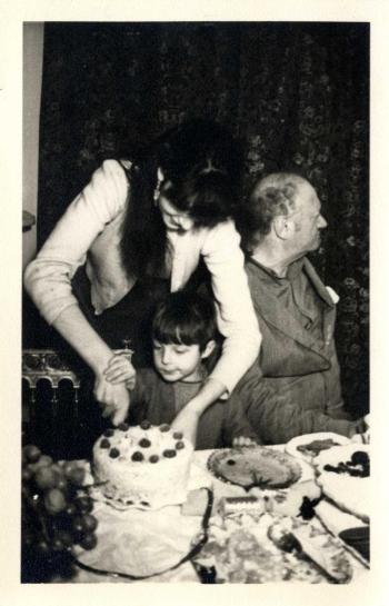 Photograph of Esther Garman cutting Roland Joffe's birthday cake